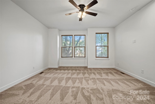 empty room featuring light carpet and ceiling fan