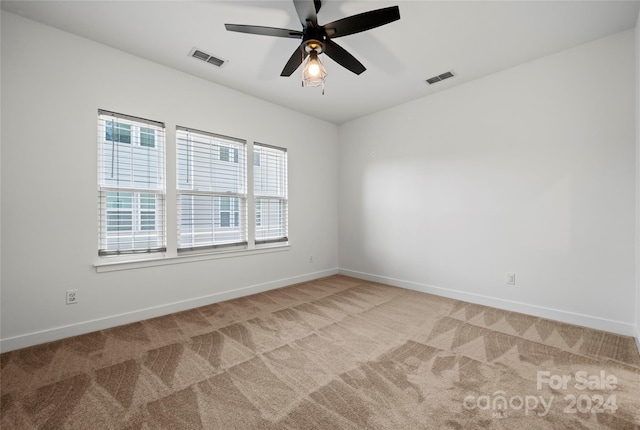 unfurnished room with ceiling fan and light colored carpet