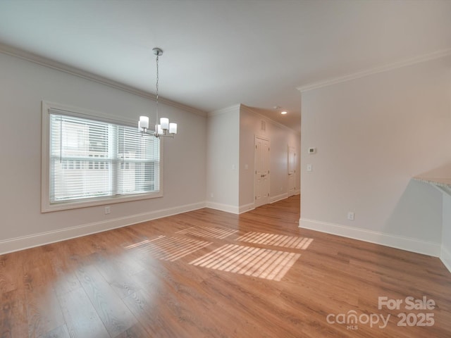 unfurnished room with crown molding, a chandelier, and light wood-type flooring