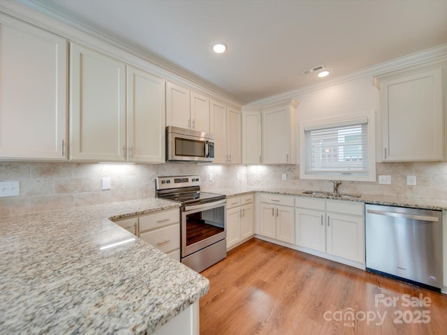 kitchen featuring light stone counters, sink, and appliances with stainless steel finishes