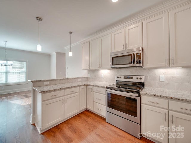 kitchen featuring kitchen peninsula, white cabinetry, hanging light fixtures, and stainless steel appliances