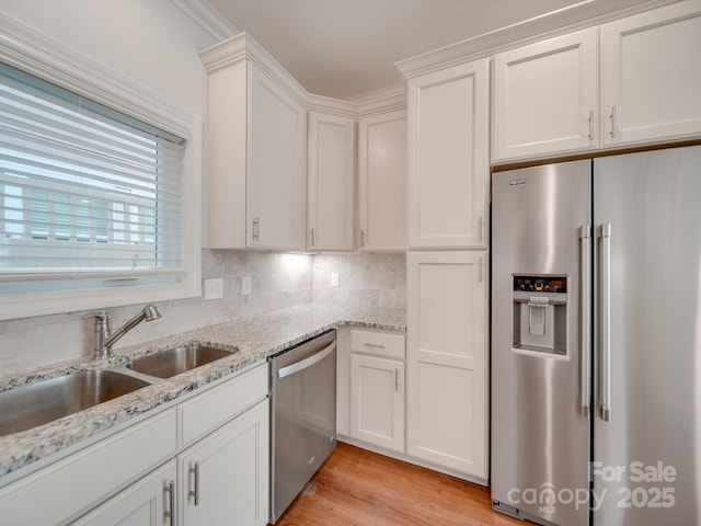 kitchen featuring light stone counters, sink, white cabinets, and appliances with stainless steel finishes