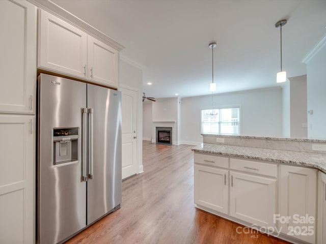 kitchen with white cabinets, ceiling fan, crown molding, and stainless steel refrigerator with ice dispenser