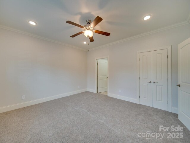 unfurnished bedroom featuring carpet flooring, ceiling fan, and crown molding