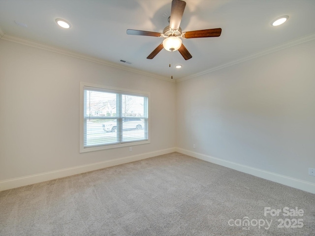 empty room featuring crown molding, carpet, and ceiling fan