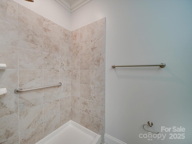 bathroom with crown molding and tiled shower