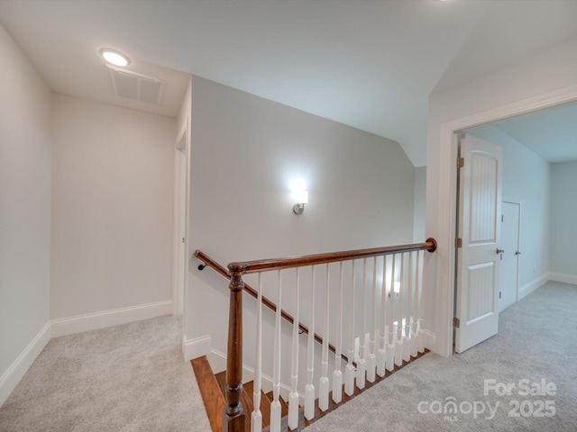 stairs featuring carpet floors and vaulted ceiling