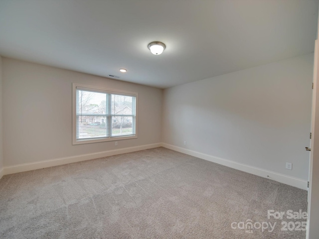 unfurnished room featuring light colored carpet