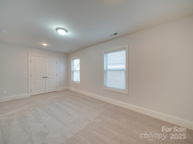 spare room featuring light colored carpet