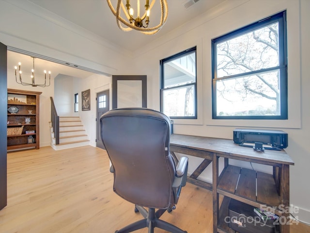 office with hardwood / wood-style flooring, crown molding, and an inviting chandelier