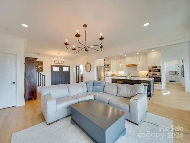 living room with an inviting chandelier and light hardwood / wood-style flooring