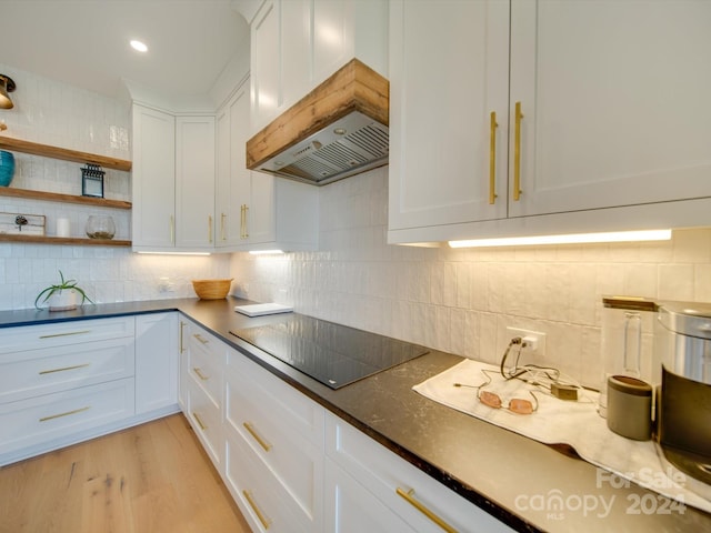 kitchen with white cabinetry, light wood-type flooring, black electric cooktop, and backsplash