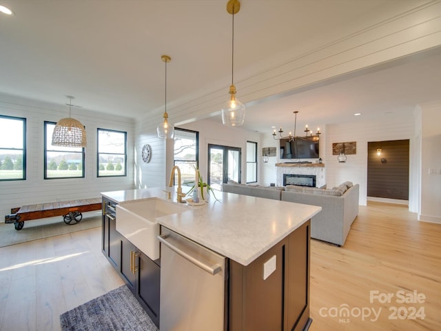 kitchen featuring dishwasher, an island with sink, a healthy amount of sunlight, and light hardwood / wood-style floors