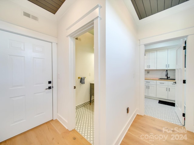 interior space with light wood-type flooring, sink, and wooden ceiling