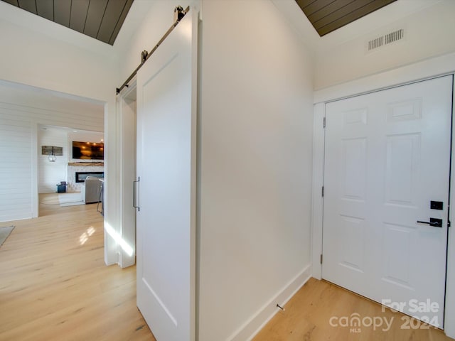 hallway featuring a barn door and light hardwood / wood-style floors