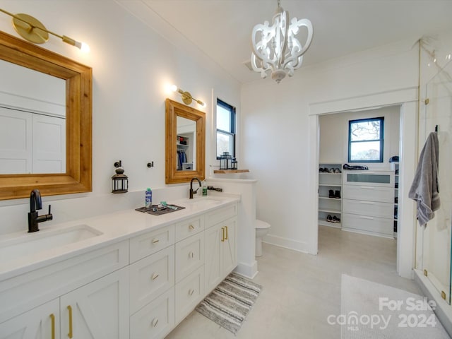 bathroom with crown molding, vanity, a chandelier, and toilet