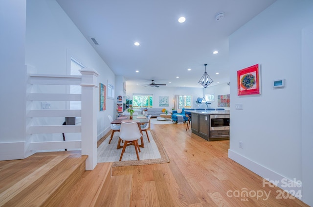 dining room with wine cooler, light hardwood / wood-style flooring, and ceiling fan