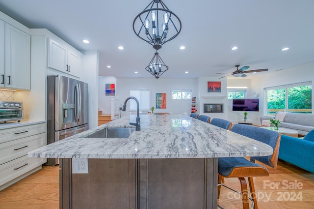 kitchen with a breakfast bar, white cabinetry, and a large island