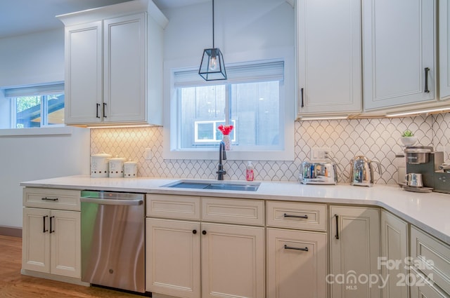 kitchen with dishwasher, sink, light hardwood / wood-style flooring, decorative backsplash, and white cabinetry