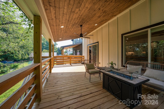 deck with a fire pit and ceiling fan