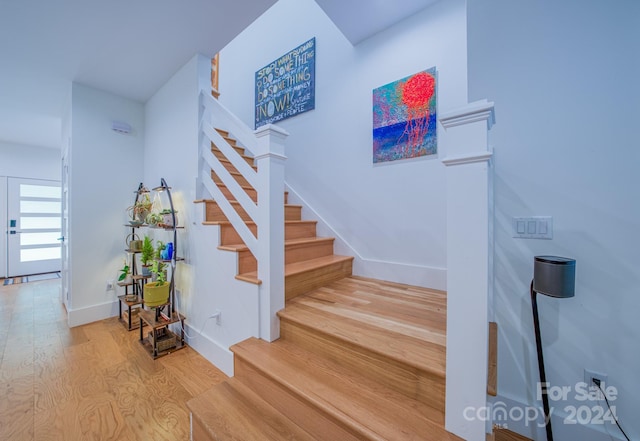 staircase with hardwood / wood-style floors