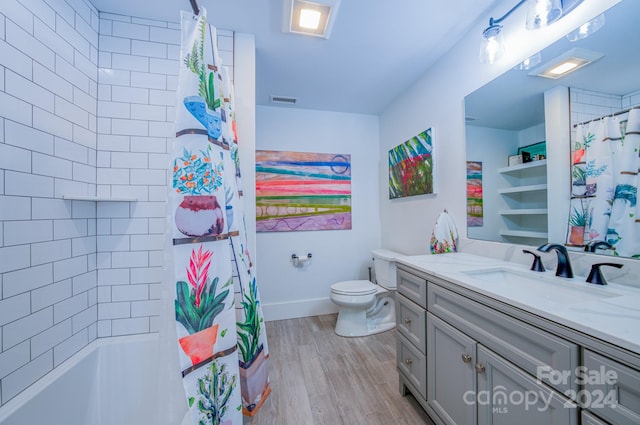 full bathroom with hardwood / wood-style floors, vanity, shower / tub combo with curtain, and toilet