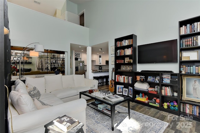 living room with hardwood / wood-style flooring and a high ceiling