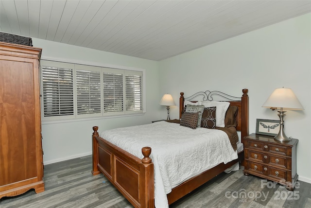 bedroom featuring dark hardwood / wood-style flooring and wooden ceiling