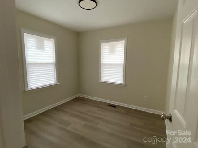 empty room featuring dark hardwood / wood-style flooring and a wealth of natural light