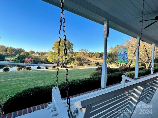 view of yard featuring ceiling fan and a water view