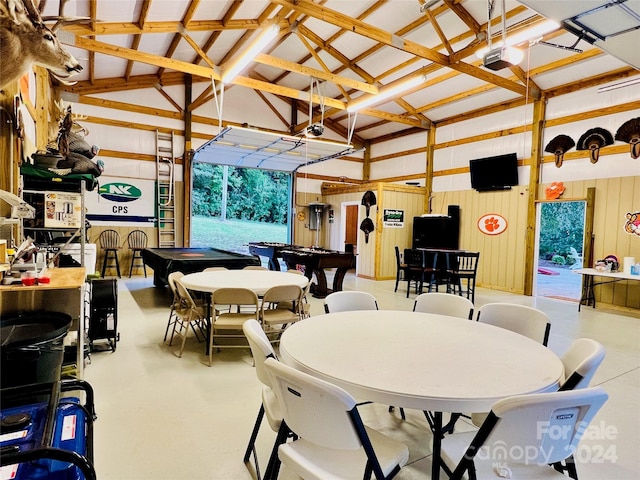 dining space with wooden walls, billiards, and concrete floors