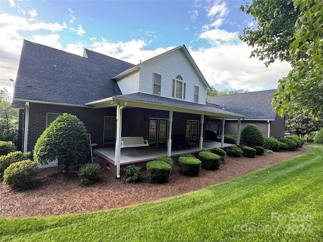 back of property with a patio and a lawn