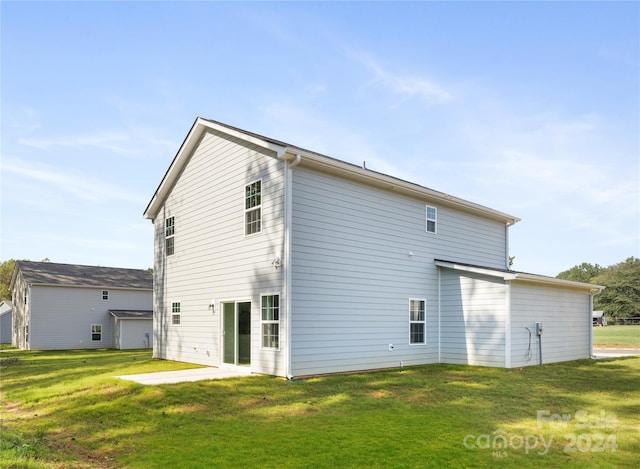 back of property featuring a patio area and a lawn