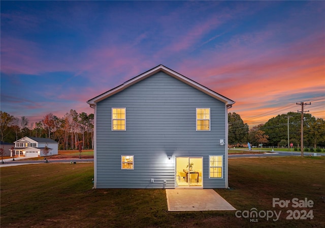 back house at dusk with a yard