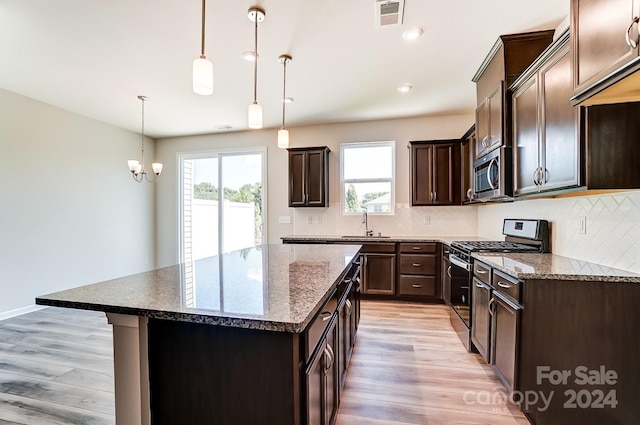 kitchen featuring light wood-type flooring, gas stove, and a kitchen island