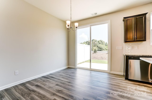 unfurnished dining area with wood-type flooring and a notable chandelier