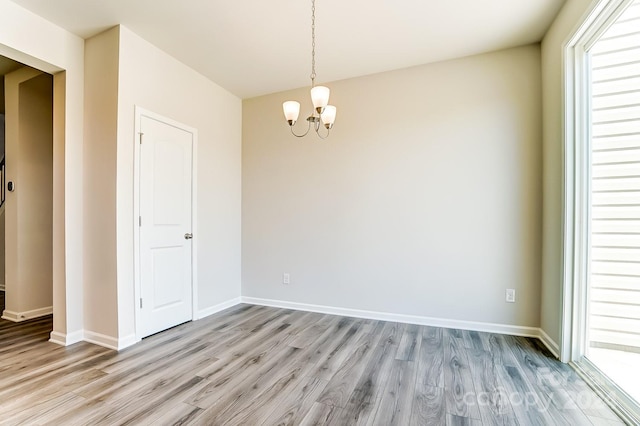 unfurnished dining area with light hardwood / wood-style floors and a chandelier