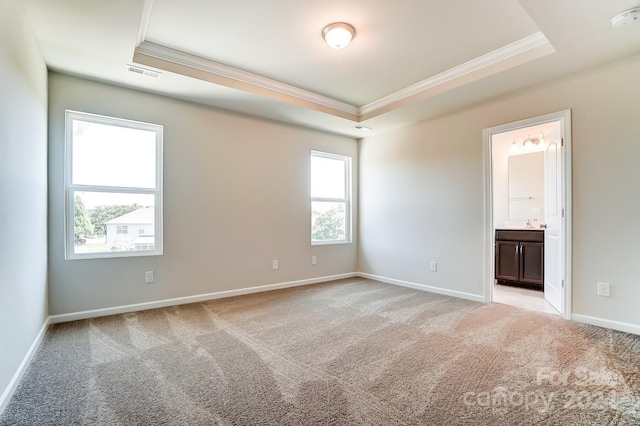 carpeted spare room with a tray ceiling and ornamental molding