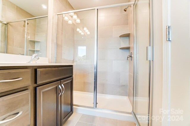 bathroom featuring vanity, tile patterned floors, and walk in shower