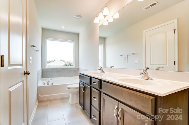 bathroom with tile patterned flooring, vanity, toilet, and a bathtub