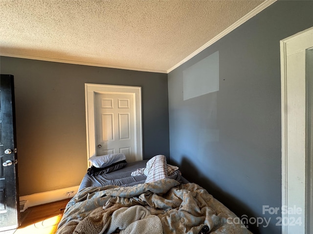 bedroom featuring a textured ceiling and ornamental molding