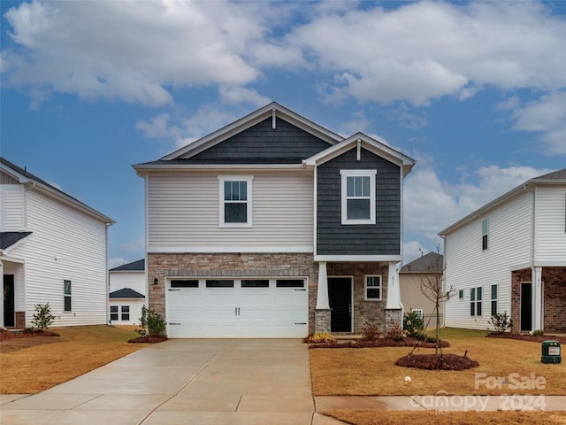 craftsman inspired home with a garage and a front lawn