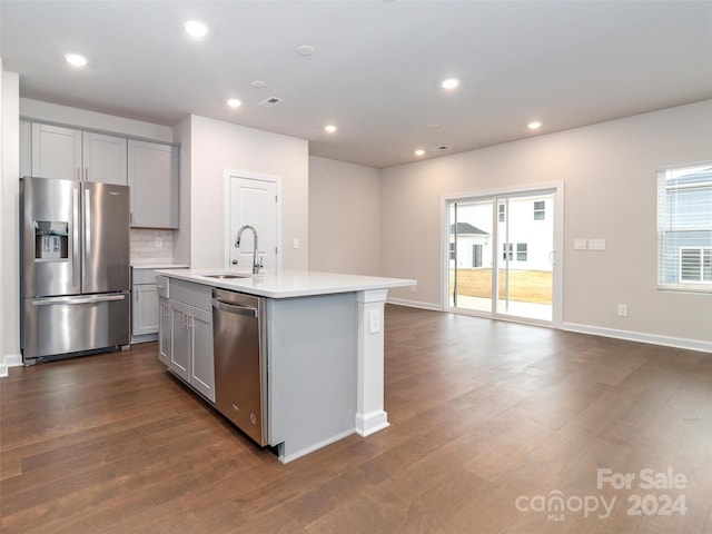 kitchen with sink, stainless steel appliances, gray cabinets, and an island with sink