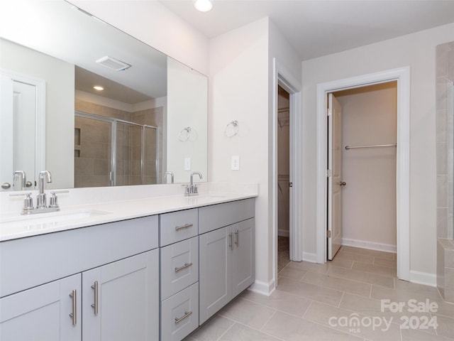 bathroom with tile patterned floors, vanity, and walk in shower