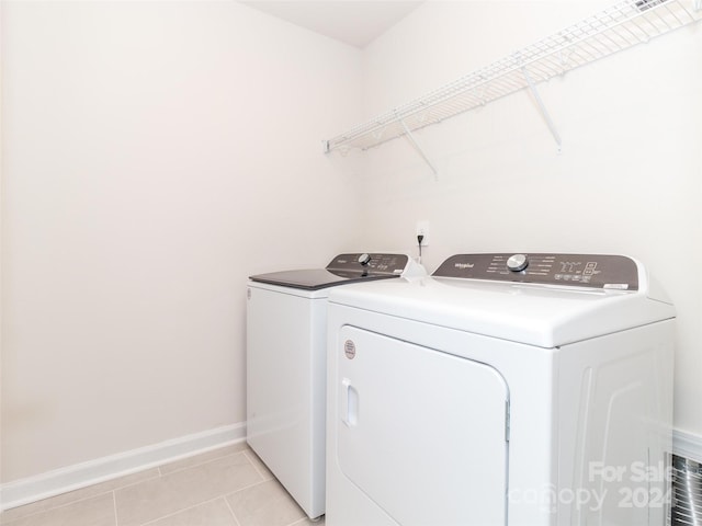 washroom featuring light tile patterned floors and washer and clothes dryer