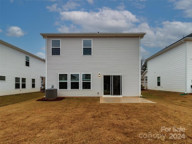 rear view of property with central AC, a patio area, and a lawn