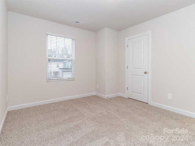 unfurnished room featuring light colored carpet