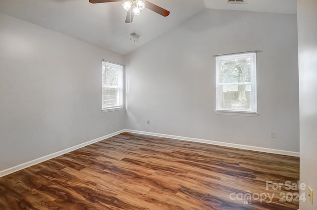 spare room with hardwood / wood-style floors, vaulted ceiling, plenty of natural light, and ceiling fan