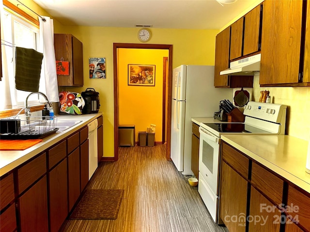 kitchen with sink, white appliances, and dark wood-type flooring