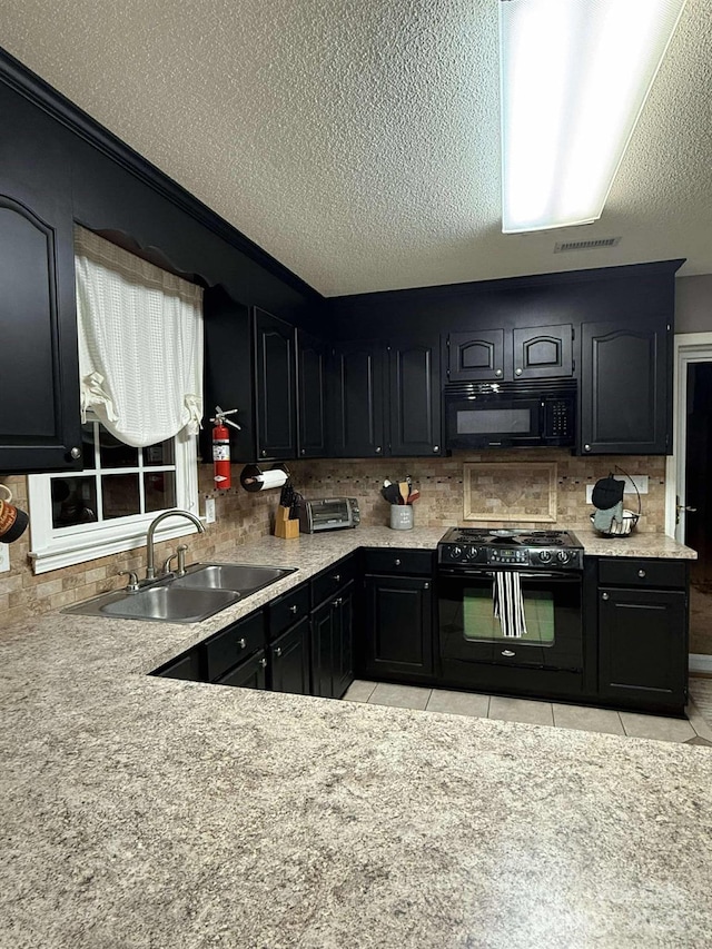 kitchen featuring a textured ceiling, light tile patterned floors, black appliances, decorative backsplash, and sink